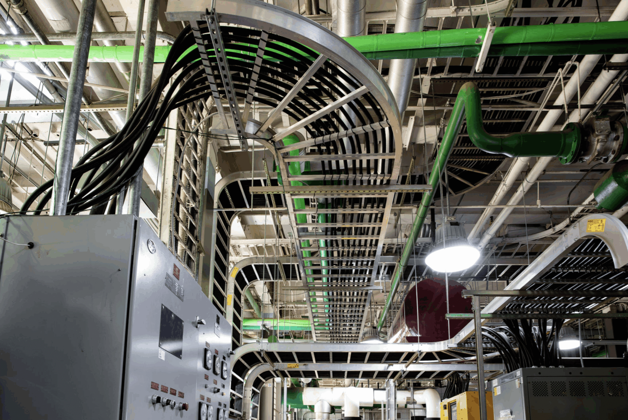An intricate network of cable trays and overhead infrastructure in a data center, demonstrating advanced power and data routing essential for high-performance operations